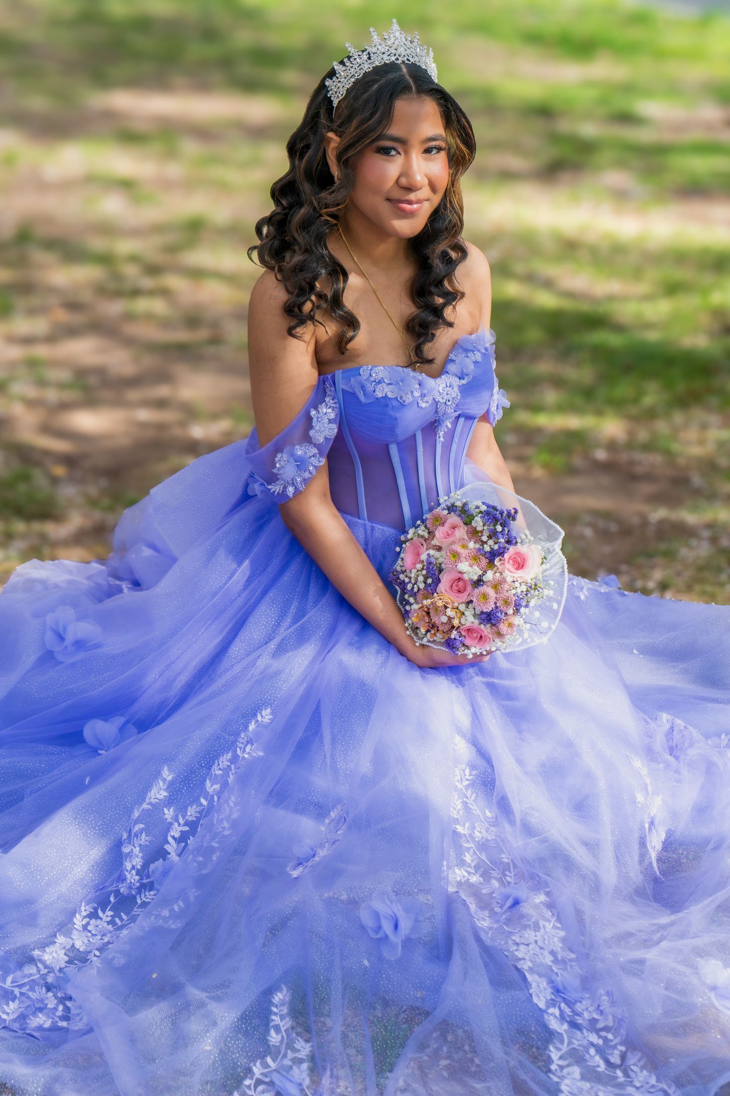 Quinceañera portrait with bouquet beneath cherry blossoms