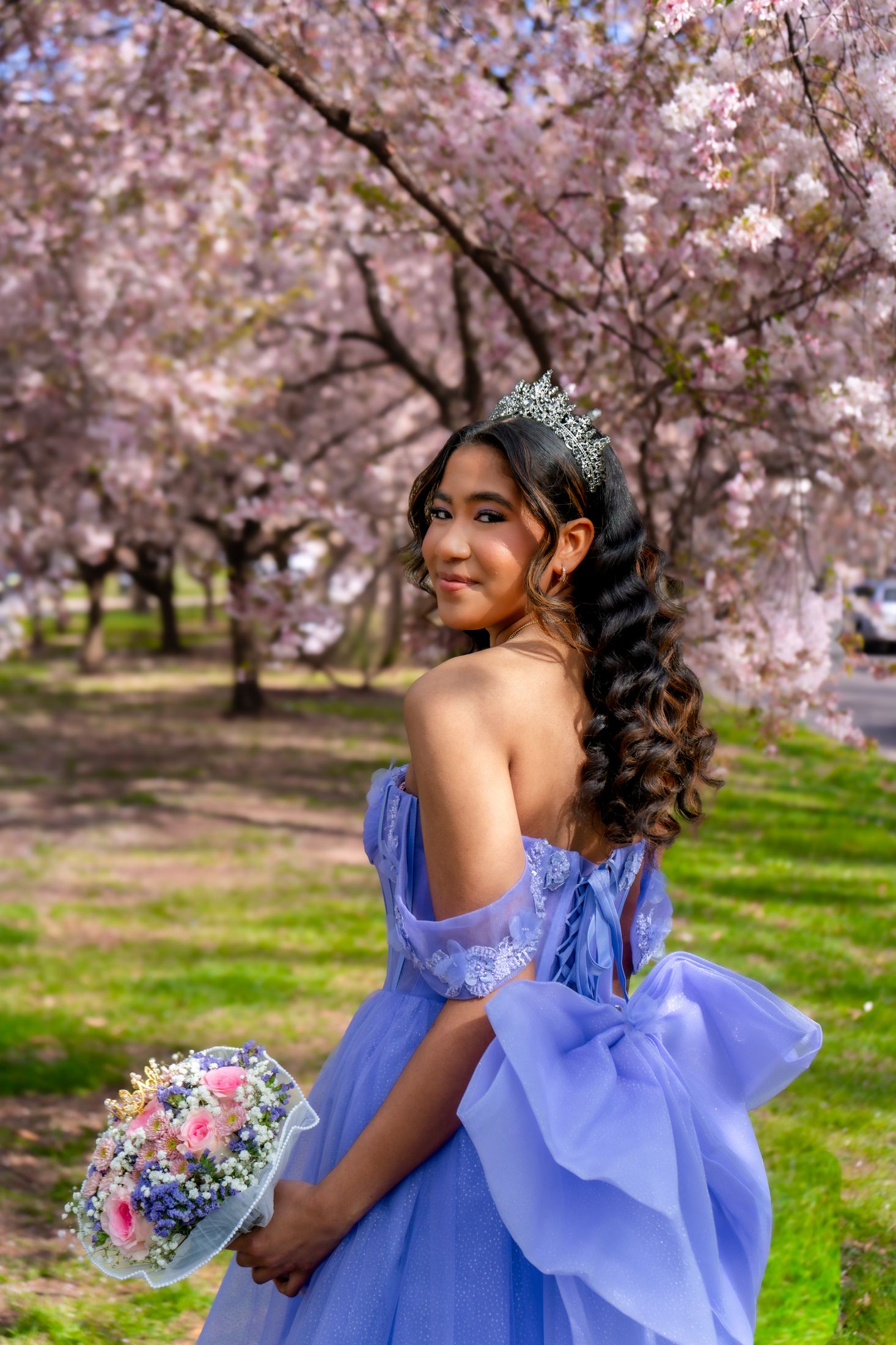 Candid quinceañera portrait among cherry blossoms