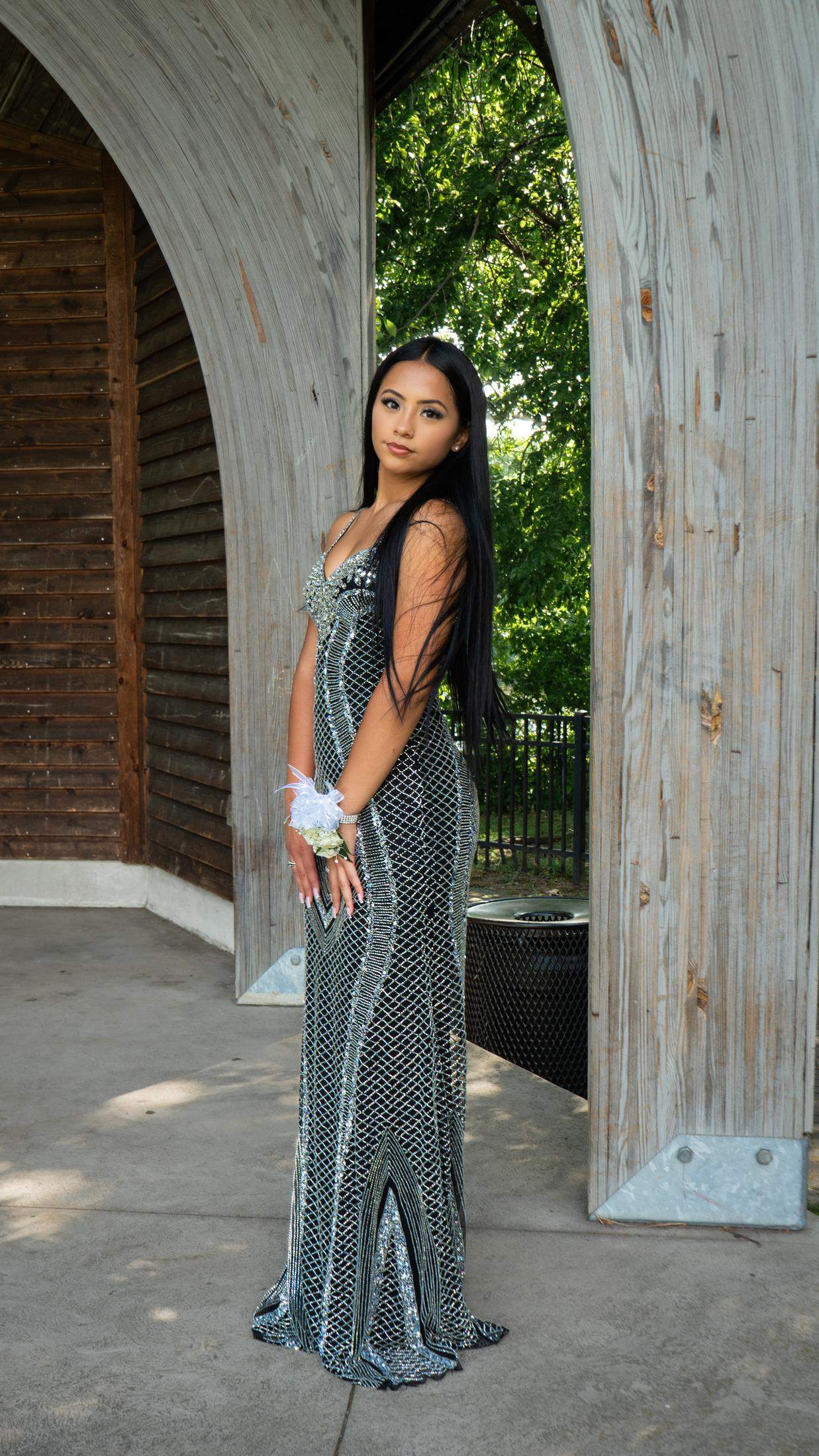 Solo prom portrait beneath a wooden arch