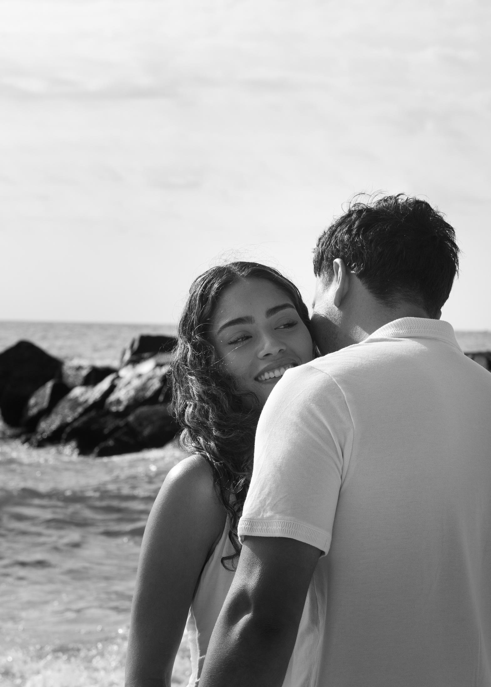 Black and white portrait of a couple embracing on the beach