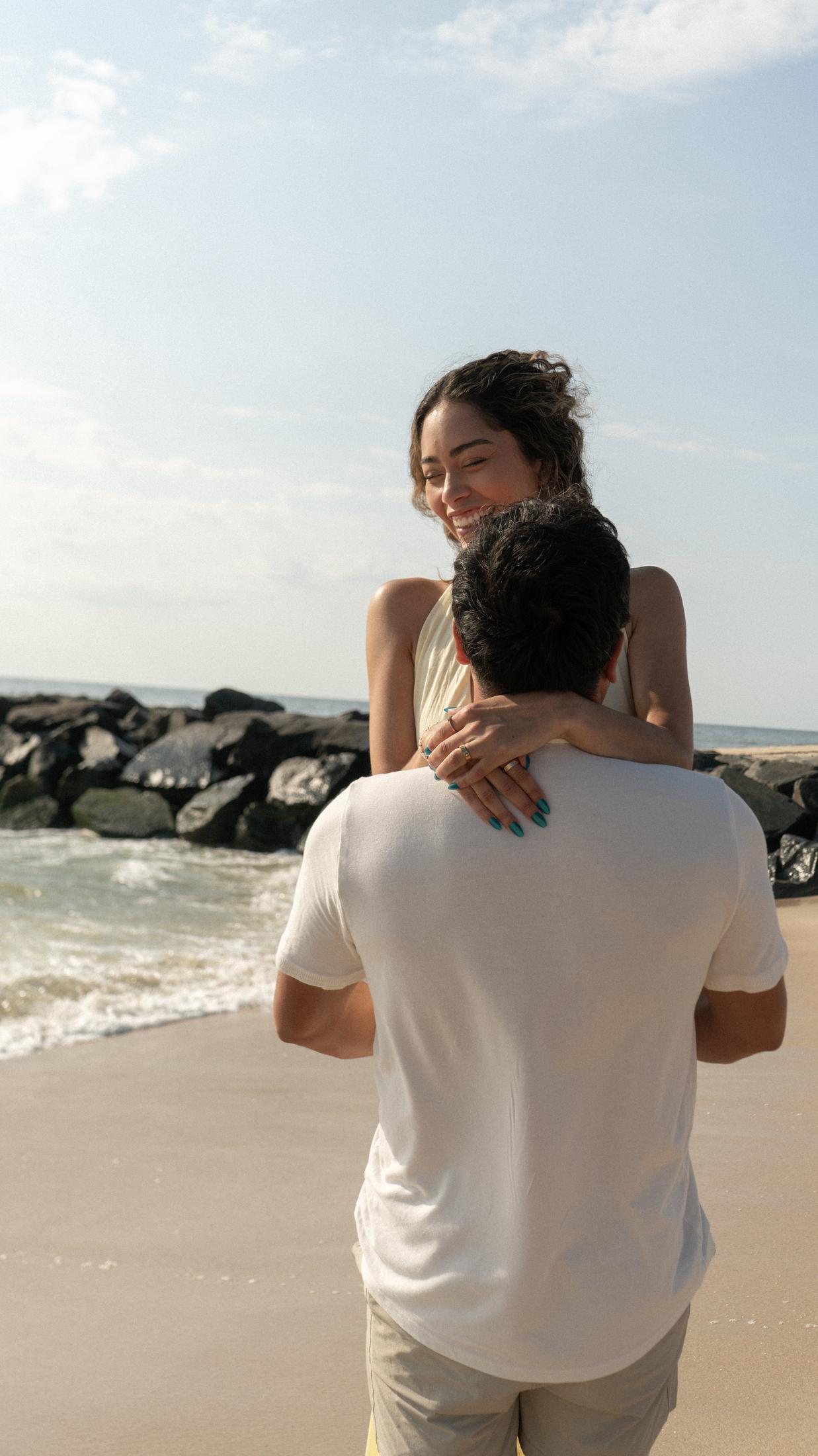 Joyful couple embrace on the beach
