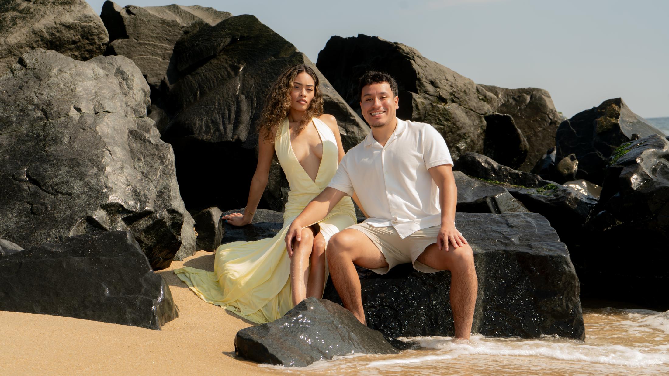 Couple sitting together on beach rocks